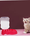 Chill Out As Your Furry Buddies Chow Down On This Pink 3.5L Automatic Pet Feeder And Water Bowl Station Featuring A Tight Leak Proof Cap And Grippy Non Slip Bottom next to a cat.