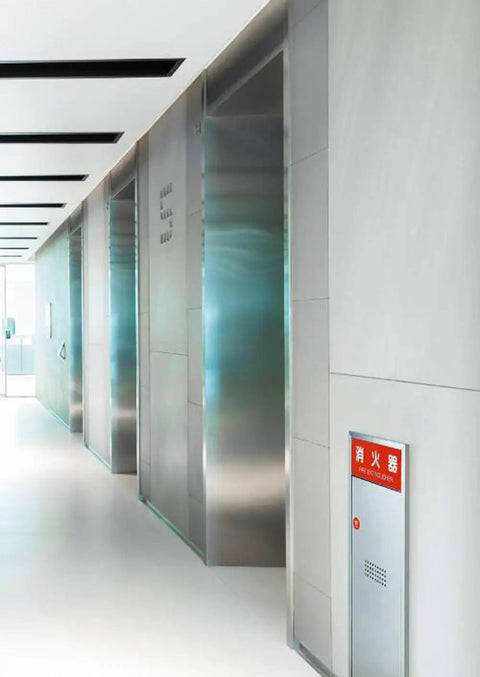 Fully Recessed Fire Extinguisher Wall Cabinet Heavy Duty Steel Safety Box mounted in a modern hall near elevators.