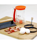 Outdoor Griddle Breakfast Prep Kit with trigger pancake batter dispenser, cast iron bacon press, and two nonstick egg rings.