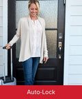 Woman standing by door with Aura Bluetooth Programmable Keypad Door Lock Deadbolt With SmartKey Security, holding suitcase handle.