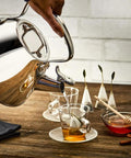 Pouring water from Specialty Stainless Steel Tea Kettle, 2 Quart, Induction Ready Pot with Visible Fill Line and Whistle into teacup