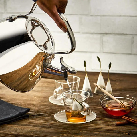 Pouring water from Specialty Stainless Steel Tea Kettle, 2 Quart, Induction Ready Pot with Visible Fill Line and Whistle into teacup