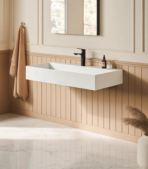 HAOCHRYSYPH Wall Mount Sink, Solid Surface, Matte White, 36 x 18 in. mounted on wall in elegantly designed bathroom.