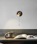 Plug In Wall Sconce Set With Chain Switch Adjustable Angle Gold Wall Lamps mounted above a desk with book and mug