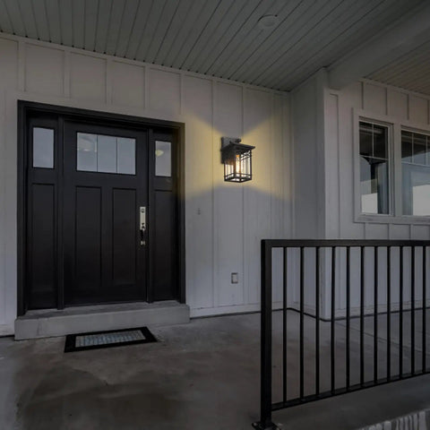 Dusk To Dawn Exterior Wall Lights With Built In Sensor illuminated on porch, showing black door and railing, 1 of 2 pack sconces.