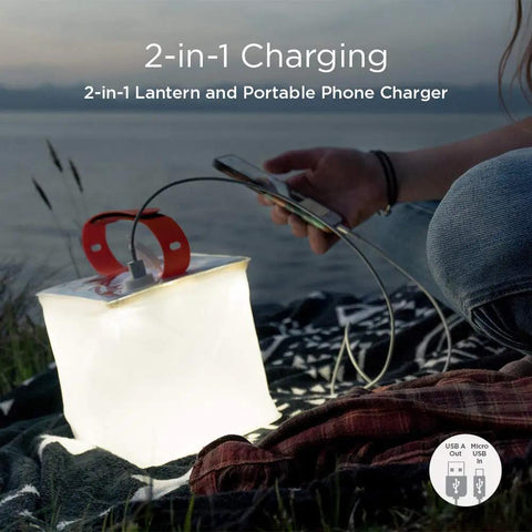 Two In One Solar Camping Lantern And Phone Charger glowing on a blanket during outdoor adventure.