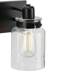 Close-up of Calhoun Collection Clear Glass Farmhouse Bath Vanity Light with antique bronze finish and thick glass shade.