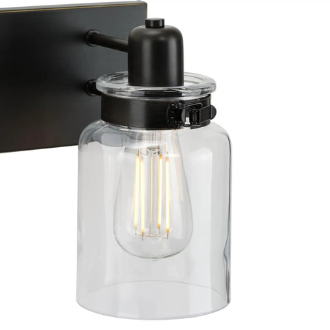 Close-up of Calhoun Collection Clear Glass Farmhouse Bath Vanity Light with antique bronze finish and thick glass shade.