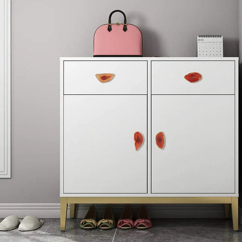 Smooth Agate Slice Drawer Knobs With Sleek Brass Handles And Glossy Gold Plated Edges on white cabinet with pink handbag.