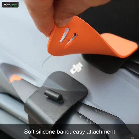 Propeller Holder And Guard Strap For DJI Air 3 And Air 3S Drones, shown being attached to blade, lightweight silicone design.
