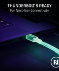 Plug And Play Thunderbolt 5 Dock With Eleven High Speed Ports And One Forty Watt Power Delivery USB C Hub For Seamless Triple Monitor Setups Ethernet Adapter SD Card Reader M Two Storage Expansion For Boss Gamers And Creators On PC Mac, close-up of illuminated Thunderbolt cable connecting to a laptop.