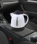 Heavy Duty 12V Portable Electric Car Kettle 1000Ml Travel Water Heater With Spill Proof Handle, black and white kettle on car console.