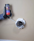 Hand using Big Gaps Spray Foam Sealant That Expands To Fill And Insulate Up To Three Inches, 12 Fl Oz Can on wall gap