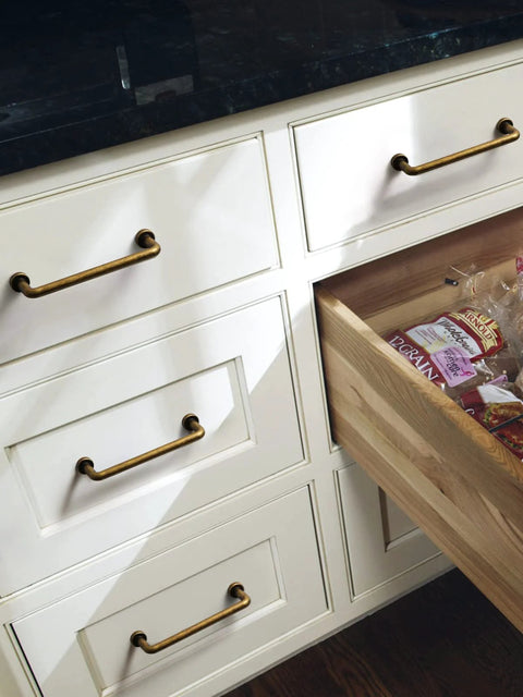 10 Pack Antique Brass Cabinet Bar Pulls 3 Inch Center To Center installed on white kitchen drawers, showcasing classic vintage style.