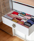 Open dresser drawer with Vintage Ship Wheel Anchor Cabinet Pull installed, displaying neatly folded clothes inside.