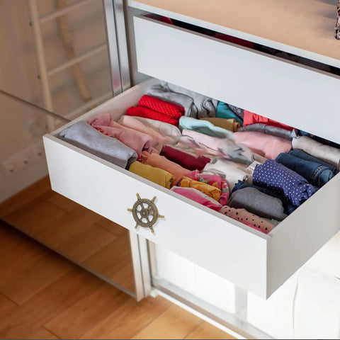 Open dresser drawer with Vintage Ship Wheel Anchor Cabinet Pull installed, displaying neatly folded clothes inside.