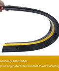 Flexible industrial-grade rubber of Ridiculously Tough Rubber Cable Ramp 1 Channel Cord Cover For Wires And Hoses, 4 Pack shown bent