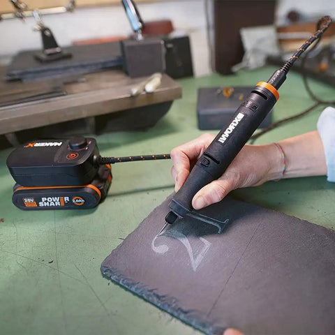 User engraving a design on slate using the Top Tier Cordless Pen Engraver And Digital Soldering Iron Kit With Sweet 20V Battery.