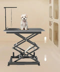 Rock Solid Electric Lift Table Rated For 180 Lbs Double Scissor Design with small dog grooming on top in garage setting.
