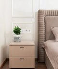 Beige bedside table with drawers featuring sleek matte black cabinet handles