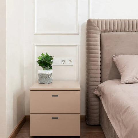 Modern bedroom with upholstered headboard and beige bedside table with plant