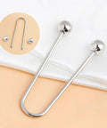 Two Pack Metal Spiral Fasteners Double Head Brooch Clips Secure Clothing And Shawl Collars Keeping Loose Garments Locked Down With Zero Drama, silver U-shaped fasteners on fabric.