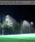 Solar Street Light Outdoor IP65 Security Flood Light illuminating parking lot at night, 20000 lumens LED with 528 beads and remote control.