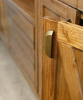 Side view of wooden cabinet door with Six Pack 5 Inch Antique Brass Half Moon Cabinet Cup Handles for kitchen drawers and cabinets.