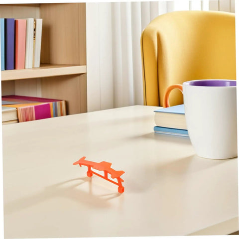 Orange bracket from 5 Piece Glider Plane Bracket Kit With Rubber Band Power For Do It Yourself Aircraft Builds on desk