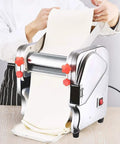 Compact Automatic Electric Pasta Maker For Fresh Homemade Noodles stainless steel with red knobs rolling dough.