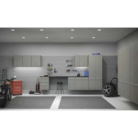 Modern garage with wall cabinets, tool storage, and clean workspace under bright overhead lighting.