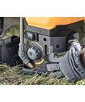 Adjusting Variflo control on 20V Max 4 Gallon Lithium Ion Cordless Backpack Sprayer Kit with 2Ah Battery in use on lawn