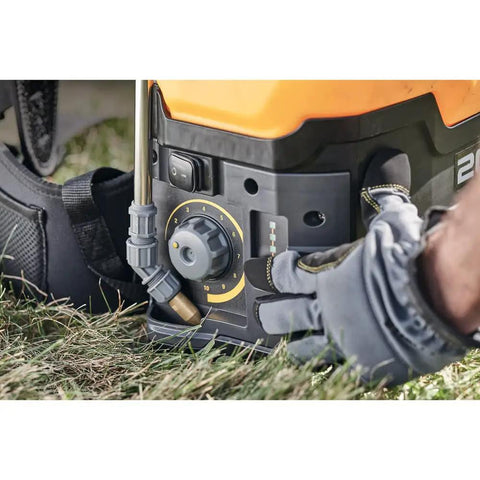 Adjusting Variflo control on 20V Max 4 Gallon Lithium Ion Cordless Backpack Sprayer Kit with 2Ah Battery in use on lawn