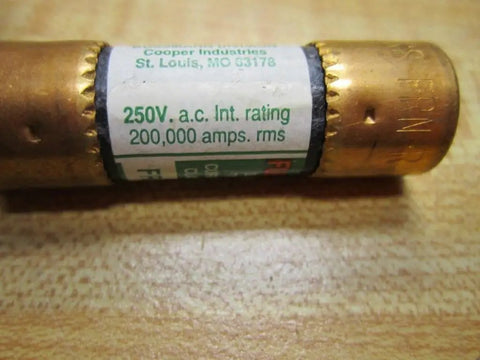 Close-up of a 250V heavy-duty time delay fuse, showing label and copper ends on a wooden surface.
