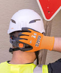 Worker wearing Rugged Knit Dipped Work Gloves With Nitrile Coating For Cut Resistance ANSI A1, adjusting helmet.
