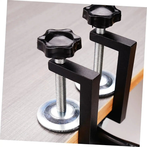 Close-up of two Outdoor Furniture Clips For Rattan And Wicker Chairs, black metal construction, easy install to stop movement and wobble.