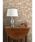 Beige botanical wallpaper with linen texture in a cozy setting featuring a lamp and books on a wooden table. Make Walls Pop With This Badass Rustic Botanical Wallpaper Featuring A Chic Linen Texture And Matte Finish Pvc Free Paste To Paper Design Guarantees Zero Drama Install For Kitchens Bathrooms Mudrooms And Commercial Spaces Because Its Made Tough Enough To.