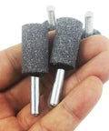Hand holding Six Piece 16 mm Cylinder Grinding Stones with One Quarter Inch Shank Aluminum Oxide Mounted Grinding Bits for drill and rotary tools.