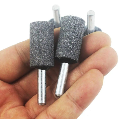 Hand holding Six Piece 16 mm Cylinder Grinding Stones with One Quarter Inch Shank Aluminum Oxide Mounted Grinding Bits for drill and rotary tools.