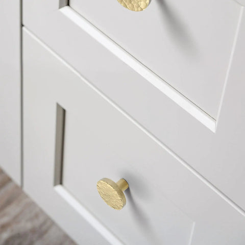Twenty Pack Dope Gold Cabinet Knobs Hammered Solid Brass Round Drawer Pulls and Handles for Kitchen Cabinets installed on white drawers.