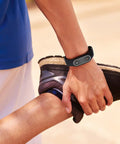 Person stretching wearing Anti Static Wrist Strap With Red Light Indicator For Esd Protection And Static Electricity Removal Unisex Black Wristband.