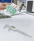 Micpointik Digital Caliper 6 Inch, 4-Way Measurement Tool on a workbench with a person analyzing a circuit board.