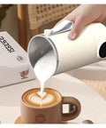 Slick Heated Self Stirring Coffee Mug With Rechargeable Electric Magnetic Mixer Stainless Steel Travel Cup pouring milk into latte.