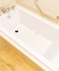 Universal Bathtub Drain Stopper Press Plug with Copper Core in a white bathtub, featuring a sleek design and ease of use.