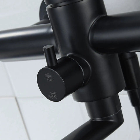 Close-up of matte black handle on wall mount kitchen faucet with side sprayer, heavy duty stainless steel commercial mixer tap.