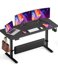 MALOL 56 Inch Electric Standing Desk With Adjustable Footrest Black setup featuring dual monitors, laptop, keyboard, and phone.