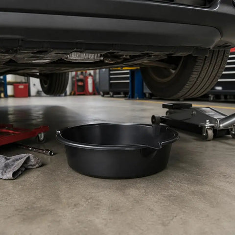 Huge 7 Qt Oil Drain Pan With Built Scale, Leak Proof Spout And Splash Guard placed under a car in a garage.