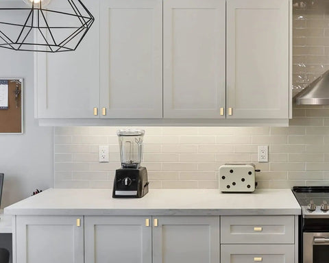 10 Pack Brushed Gold Cabinet Knobs Set, 1.46-Inch Rectangle Single Hole Drawer Pulls installed on modern white cabinets.
