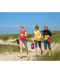 Three people carrying Rainbow 1.8 Stunt Kite for Beginners and Pros with Dual Line Foil Sport Kite, walking on a sandy beach.