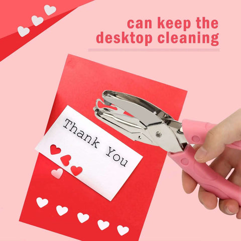 Heart And Star One Quarter Inch Metal Handheld Paper Punch Set With Soft Handled Design punching hearts into red paper for crafting.